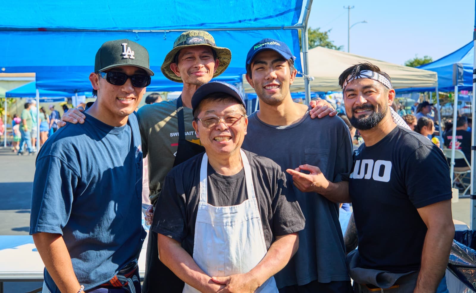The summer festival cooking crew under the food booth canopy