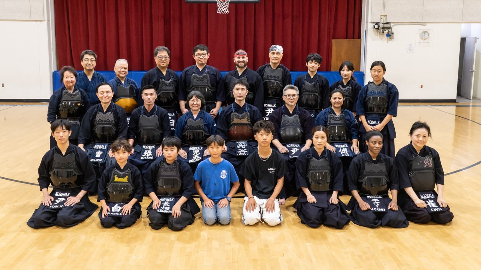 Kendo students and instructors in armor, gathered in the center's gym