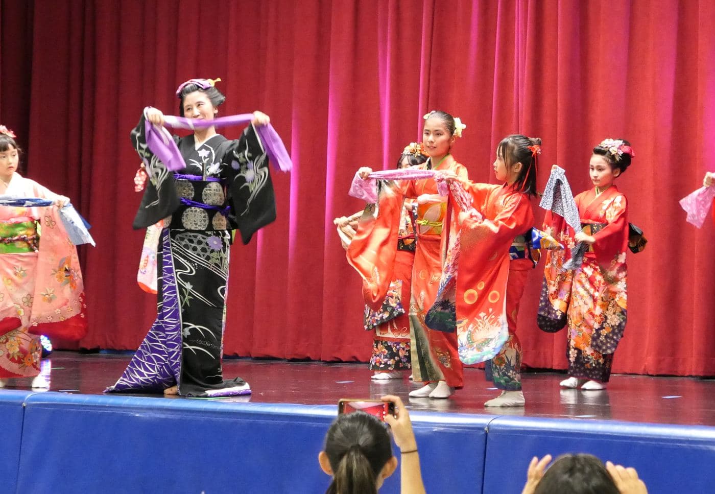 Children in kimono dancing with scarves on the center's stage